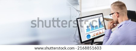 Close-up Of A Businessman Analyzing Business Graph On Computer In Office