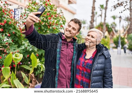 Mother and son smiling confident making selfie by the smartphone at park