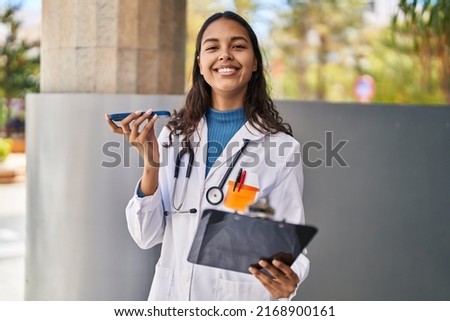 Young african american woman doctor talking on the smartphone at street