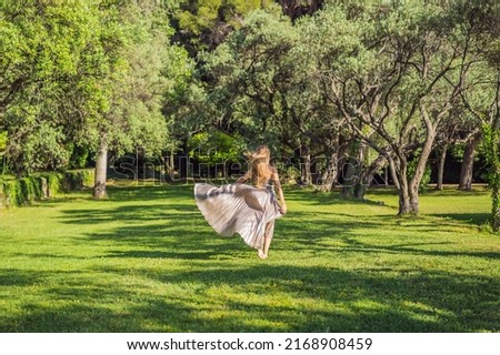 Woman tourist walking in Montenegro. Panoramic summer landscape of the beautiful green Royal park Milocer on the shore of the the Adriatic Sea, Montenegro