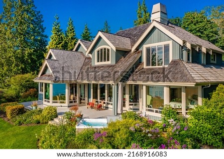 Stately waterfront home in pacific northwest with ocean views expansive decks hot tub front porch and long paved driveway Royalty-Free Stock Photo #2168916083