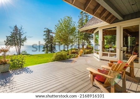 Stately waterfront home in pacific northwest with ocean views expansive decks hot tub front porch and long paved driveway Royalty-Free Stock Photo #2168916101