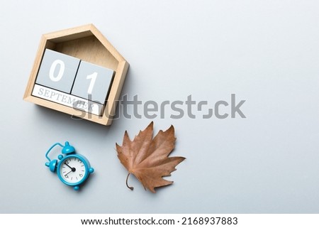 Calendar for September top view with copy space. Wooden calendar block with date 1 September with falling autumn leaves background. Royalty-Free Stock Photo #2168937883
