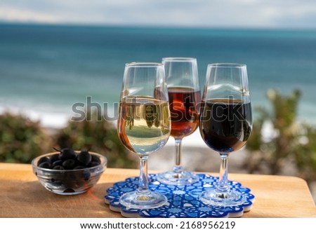Tasting of Spanish sweet and dry fortified Vino de Jerez sherry wine and green olives with view on blue sea and beach near El Puerto de Santa Maria, Andalusia, Spain Royalty-Free Stock Photo #2168956219