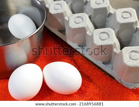 Chicken white eggs in saucepan ready for cooking and their cardboard package
