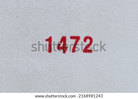 Red Number 1472 on the white wall. Spray paint.
