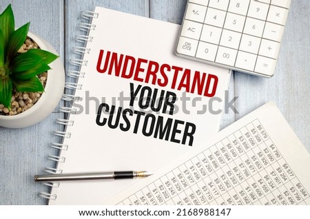 UNDERSTAND YOUR CUSTOMER text on a sticky on notebook with pen and calculator