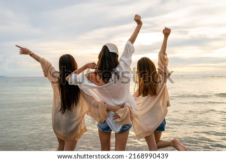 Group of Young Asian woman in walking and playing together on tropical beach at summer sunset. Happy female friends enjoy and fun outdoor activity lifestyle on holiday travel vacation at the sea Royalty-Free Stock Photo #2168990439