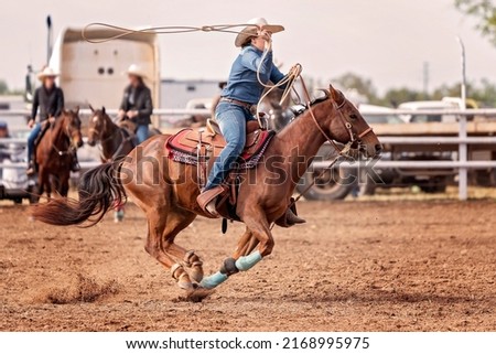 Female Rider competing in barrel race on horse at country rodeo Australia Royalty-Free Stock Photo #2168995975