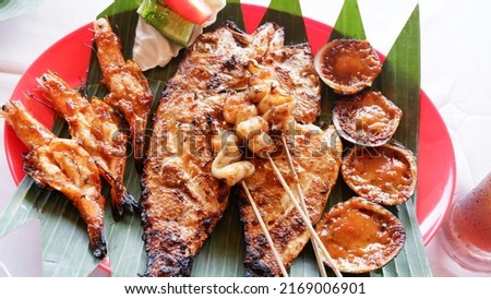 closeup Assorted grilled seafood, served on a plate lined with banana leaves. the concept of grilled food in a seaside restaurant