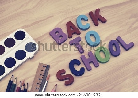 the phrase back to school is laid out in multicolored letters on the table a fountain pen a paint brush a ruler next to the concept of education school. High quality photo