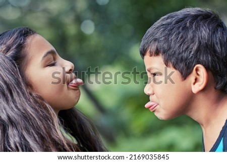 Two little troublemakers. Shot of a young brother and sister teasing each other while playing outside. Royalty-Free Stock Photo #2169035845