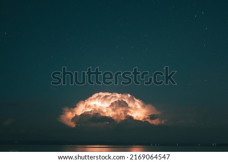 Distant thunderstorm crowded by stars