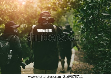 Volunteer working team walking survey in the forest for wildlife photography research and protection.