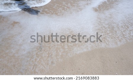 Ocean waves with soft foam on tropical sandy beach on summer background with copy space. web banner background