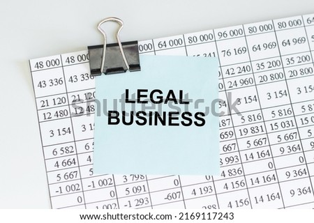 Legal business text on the card that is clamped to the sheet with the accounting report