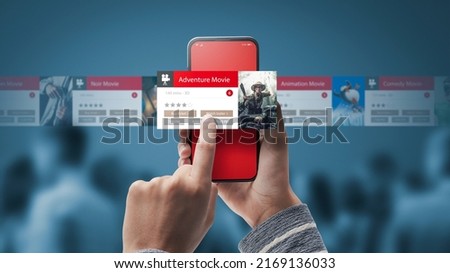 Woman browsing movies online on her smartphone, cinema and entertainment app concept Royalty-Free Stock Photo #2169136033