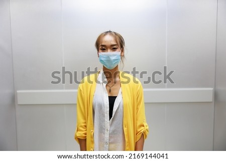 Asian woman people standing in modern elevator at modern business center building.