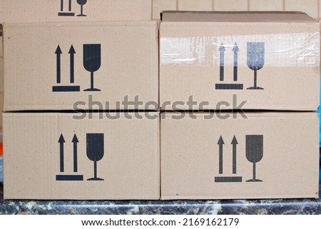 Postal boxes. Cardboard postal box package parcel in a post office warehouse. Parcel box with printed signs Do not turn over and fragile. Paper boxes for parcels in regular rectangular design.