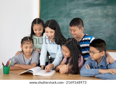 Asian female teacher teaching her students in classroom, education concept Royalty-Free Stock Photo #2169168973