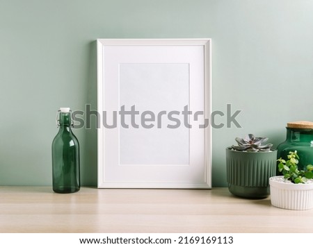 Blank frame mockup for artwork or print on green wall background.
Interior design of living room with white mock up photo frame. Scandinavian interior design.