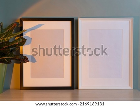 Blank frames mockup for artwork or print on green wall background.
Interior design of living room with black and white mock up photo frames. Scandinavian interior design.