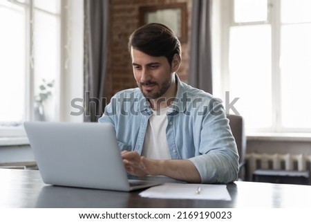 Man typing on laptop keyboard working sit at desk in modern office workspace. Freelancer makes on-line telecommuting task, texting answers to client via e-mail, solve business remotely. Tech concept Royalty-Free Stock Photo #2169190023