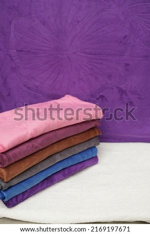 Pile of soft colorful clean towels. Flowers in the background. comfortable and cool towels Royalty-Free Stock Photo #2169197671