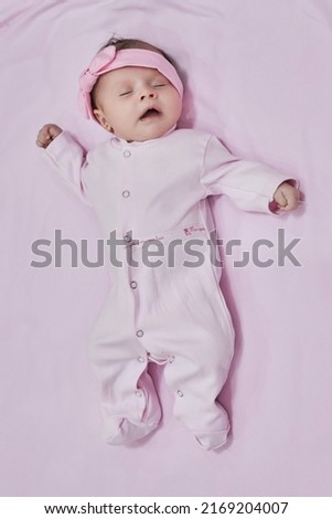 Newborn baby girl sleep on pink blan. Close up