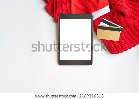 Plastic credit card mockup and tablet. Color red and white background. Atm empty debit payment. Currency shopping with stripe. Christmas hat. new year concept mockup