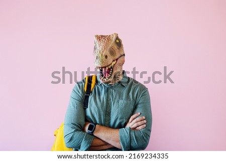 Man with lizard mask on pink background.