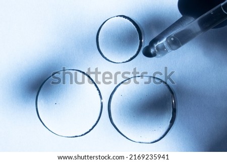 Cosmetic transparent liquid product, peptide, collagen on a blue background with a glass dropper.