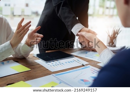 Asian entrepreneurs handshakes to congratulate the agreement between the two companies to enhance investment and financial strength. deal concept