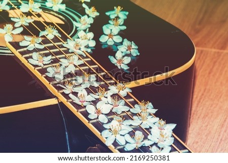 Flowers on a musical instrument. Color guitar with flowers. Beautiful flowers