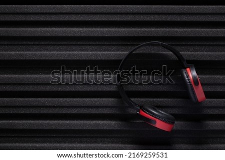 Music headphones and acoustic foam wall background texture. Soundproof material for record studio room Royalty-Free Stock Photo #2169259531