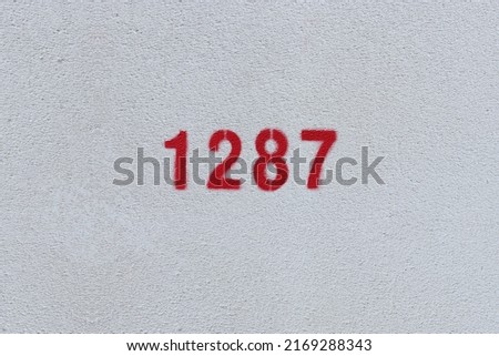 Red Number 1287 on the white wall. Spray paint.
