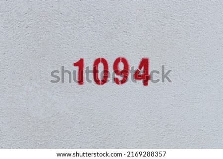 Red Number 1094 on the white wall. Spray paint.
