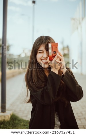 Young woman taking pictures with an analog camera. Concept of travel, people and lifestyles.