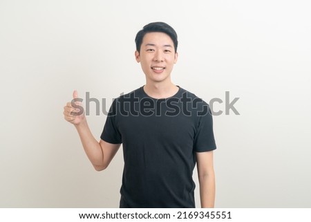 portrait young Asian man thumbs up or ok hand sign on white background