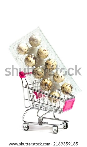 Small quail eggs in a shopping trolley on a white background, healthy food