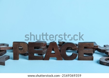 Word PEACE with letters on blue background. Alphabet concept