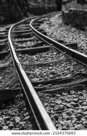 black and white image of the old tracks on a curve 