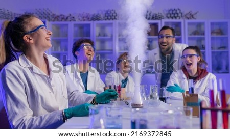 Excited science students with teacher doing chemical experiment in the laboratory at university. Royalty-Free Stock Photo #2169372845