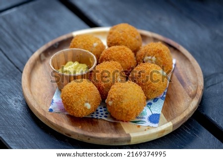 Bitterballen, Dutch meat-based snack in white plate served with mustard on wooden tabel background, Typically containing a mixture of beef or veal, Bitterballen are one of Holland's favorite snacks. Royalty-Free Stock Photo #2169374995