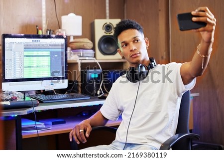 On my music studio grind. Cropped shot of a handsome young male music producer taking selfies while working in his home office.