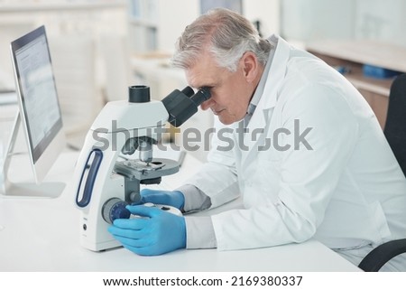 Theres a lot to take note of when magnified. Shot of a mature scientist using a microscope in a lab. Royalty-Free Stock Photo #2169380337