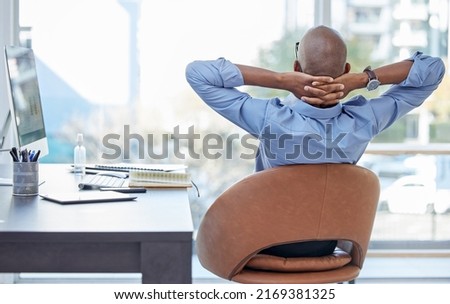 Being the boss has its perks. Shot of a businessman looking relaxed while sitting in his office. Royalty-Free Stock Photo #2169381325
