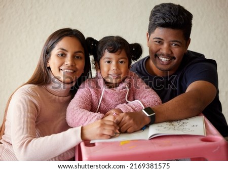 Theses are precious moments with our daughter. Shot of a young parents helping their little girl complete a colouring book.