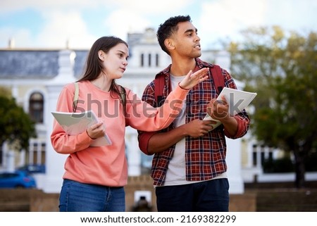 Thats where everyone hangs out. Shot of a young woman showing a fellow student around. Royalty-Free Stock Photo #2169382299