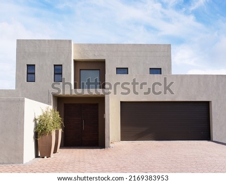Shot of a modern house in the suburbs - The house designs displayed in this image represent a simulation of a real product and have been changed or altered enough by our team of retouching and design Royalty-Free Stock Photo #2169383953